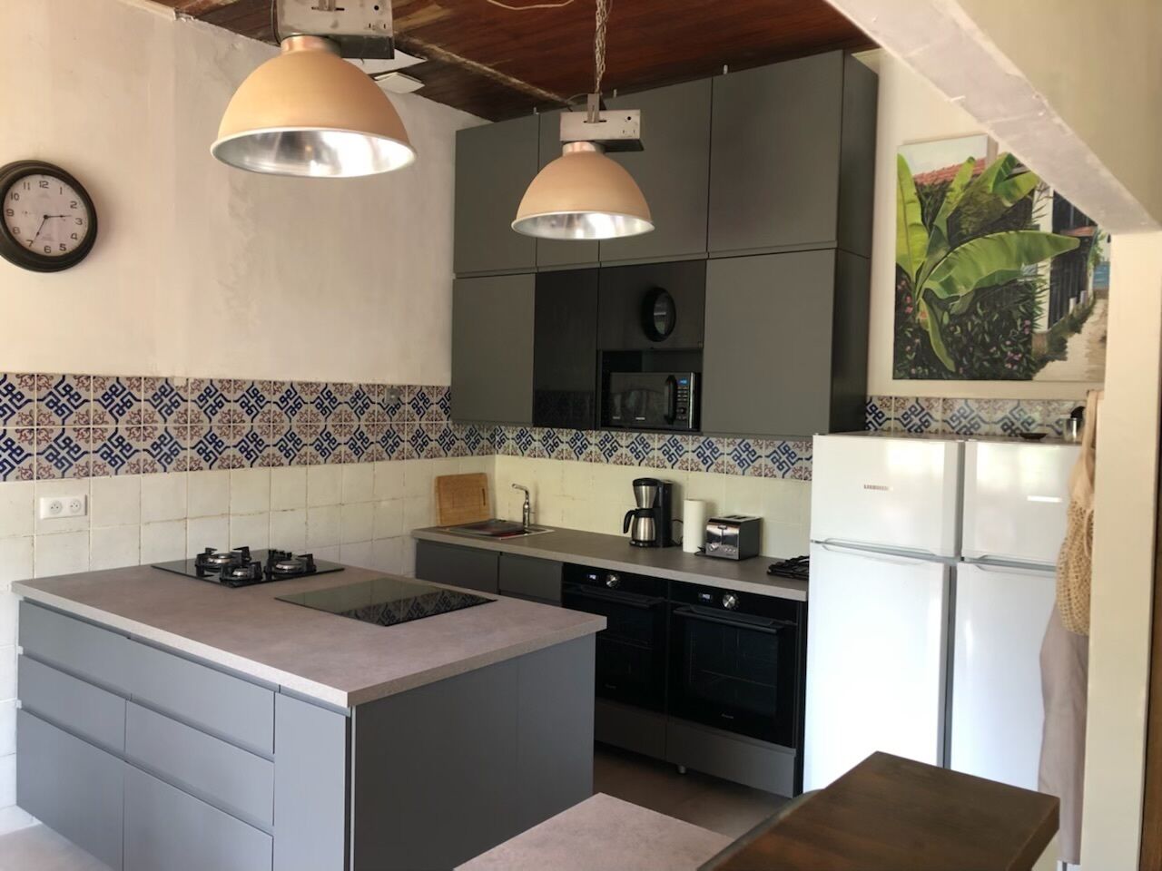 A compact kitchen with a central island, a microwave, a coffee maker, and a refrigerator.