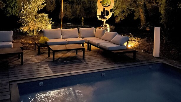 A poolside area with a wooden deck, a large umbrella, and a seating arrangement. - Family villa with pool and outbuilding, very large grounds (Cap Ferret)
