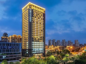 Un hôtel de grande hauteur au design moderne, doté de nombreuses fenêtres et d’une entrée imposante.