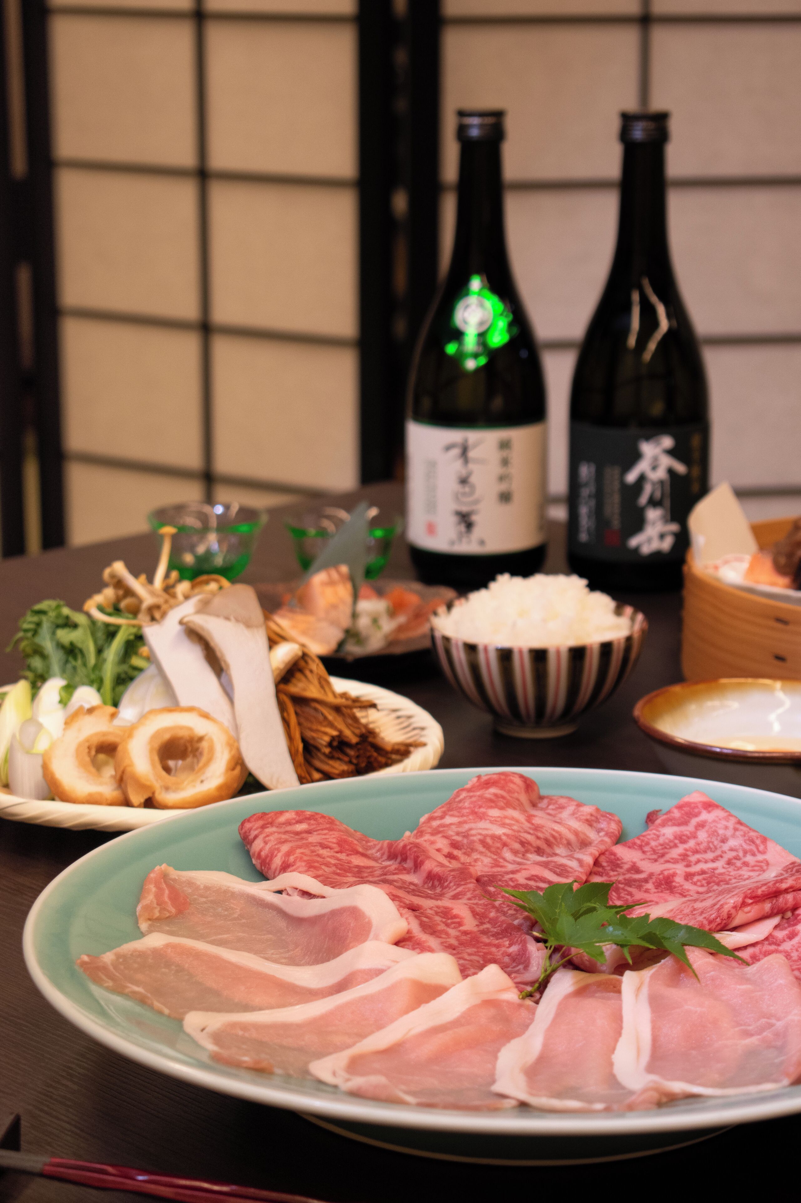 Una mesa con diversos alimentos, incluyendo carne, verduras y una botella de bebida.