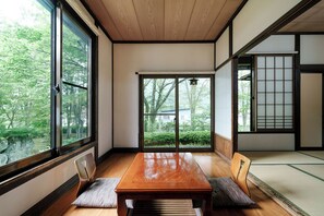 Una habitación japonesa tradicional con suelo de tatami, una mesa de madera y puertas correderas.