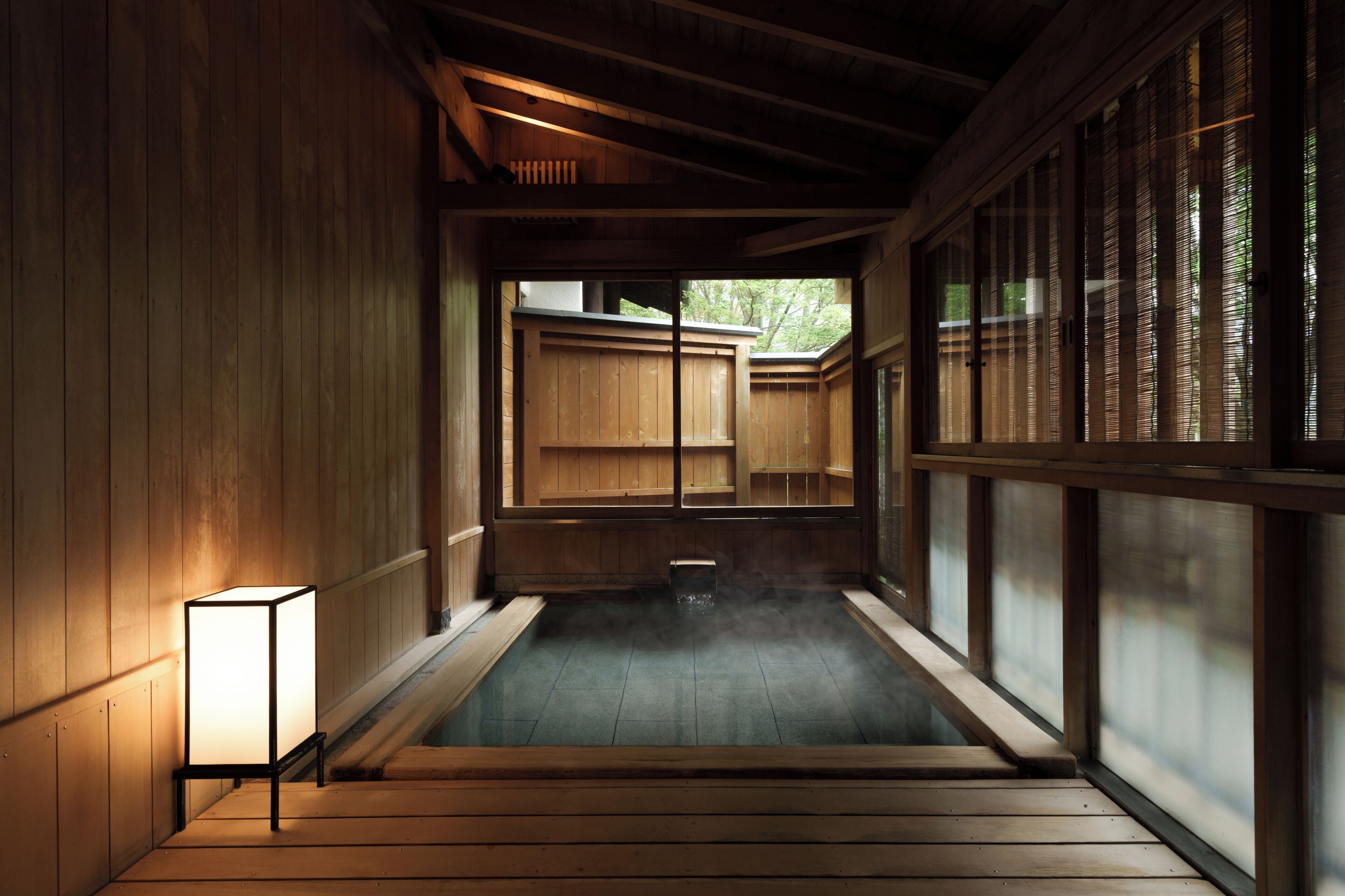 A traditional Japanese onsen with wooden walls and a tiled floor.