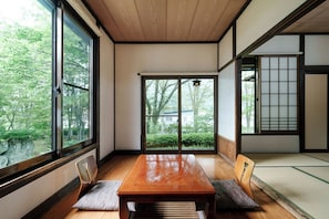 Ein traditioneller japanischer Raum mit Tatami-Böden, einem Holztisch und Schiebetüren.
