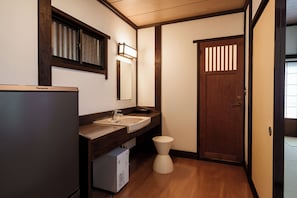 Ein kleines Badezimmer mit Waschbecken, Spiegel und Toilette.