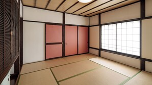 A traditional Japanese room with tatami flooring, sliding doors, and a large window.