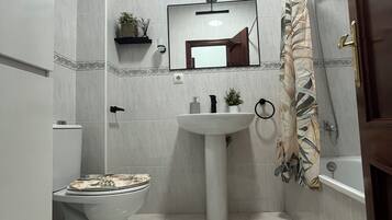 Een haardroger, handdoeken, zeep, toiletpapier