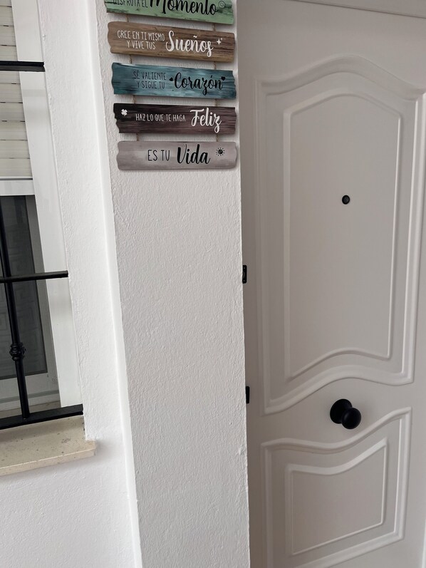 A white door with a decorative panel featuring wooden signs with inspirational messages.