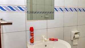 A bathroom with a white sink, a mirror, a toothbrush holder, and a hand soap dispenser. - Curated modern studio in mombasa Nyali, 5 mins drive to nyali beach (Mombasa)