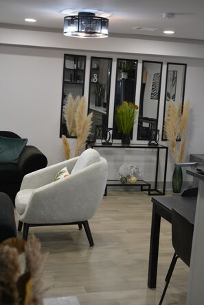 Ein modernes Wohnzimmer mit einer Couch, einem Couchtisch und Zierpflanzen.