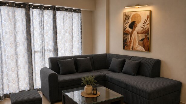 Ein modernes Wohnzimmer mit einem Ecksofa, einem Glastisch und einem Bild an der Wand.