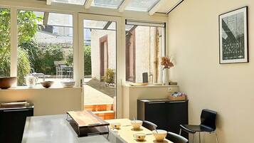 Eine moderne Küche mit einer großen Kochinsel, einem Esstisch und einer Glasdecke.