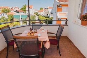 Ein Balkon mit Tisch für zwei Personen, Stühlen und Blick auf die Umgebung.