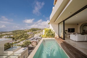 Una piscina en la azotea con vistas a un pueblo en la ladera.