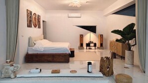 A modern bedroom with a bed, bedside tables, a desk, a plant, and a large window. - 台灣「台東十景」清晨無人的別墅區可眺望湖邊迎接美好假期最重要的一刻 (Chishang Township)