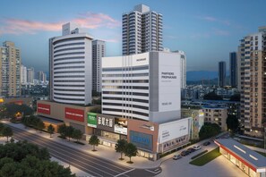 A modern hotel with a curved facade, multiple floors, and a prominent sign for 'PHIFFIER PROPAKAIGE'. - MOTRI HOTEL Futian Huaqiang North Branch (Shenzhen)