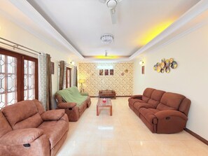 Ein Wohnzimmer mit zwei braunen Sofas, einem Couchtisch und einer Wand mit Muster.