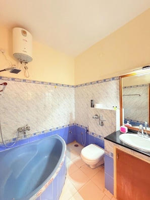Ein Badezimmer mit Badewanne, Toilette, Waschbecken und einem Spiegel.