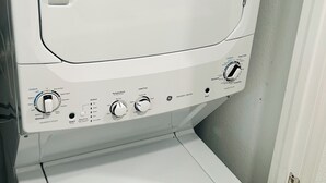 Etupuolelta kuvattu valkoinen pesu- ja kuivauskonemalli, jossa on säätönupit, käynnistyspainike ja tarra, joka osoittaa, että laite on ENERGY STAR -sertifioitu.