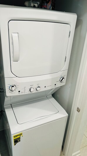 Eine Frontansicht einer weißen Waschmaschine und eines Trockners mit Bedienknöpfen, einem Startknopf und einem Aufkleber mit der ENERGY STAR-Zertifizierung.