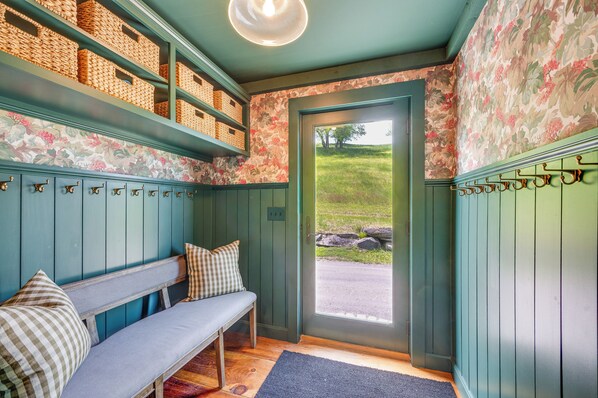 A room with a bench, wicker baskets, and a door leading outside. - 95-Acre Countryside Estate! Luxe Vermont Farmhouse (Chelsea)