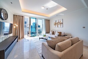 Ein modernes Wohnzimmer mit einer Couch, einem Couchtisch, einem Fernseher und Blick auf die Stadt durch große Fenster.