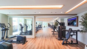 A gym with treadmills, exercise bikes, and weight machines. - Luxury 1BR Marina & Harbor View Beachfront (Dubai)
