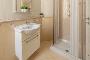 Un bagno con lavandino, specchio e doccia.
