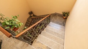 Eine Treppe mit einer Holzhandläufe, Steinabstufungen und Blumentöpfen.