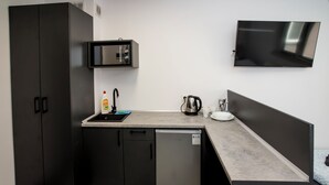 A compact kitchenette with a microwave, refrigerator, and coffee maker. - Mia Mia House (Katowice)