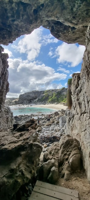 Eine felsige Küstenlandschaft mit freiem Blick auf das Meer und einem Sandstrand.