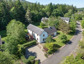 Une maison à deux étages avec une allée pavée et une pelouse.