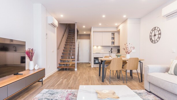 Una sala de estar moderna con un sofá, una mesa de centro y un comedor con sillas y una mesa.