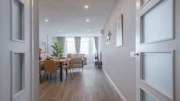 Un interior moderno con comedor, sofá y planta.