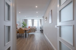 Un interior moderno con comedor, sofá y planta.