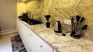 Una cocina moderna con encimeras de granito, electrodomésticos de acero inoxidable y una campana extractora negra.