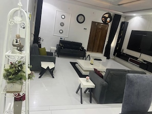 Una sala de estar moderna con sofá, mesa de centro, televisor y objetos decorativos.