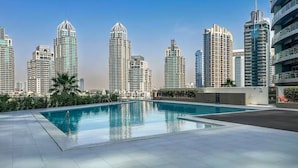 A rooftop pool with a city skyline in the background. - Premium Skyline 1BR with Sea View LIV Marina (Dubai)