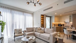 A modern living room with a sectional sofa, a coffee table, and a dining area with a table and chairs. - Premium Skyline 1BR with Sea View LIV Marina (Dubai)