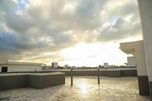A rooftop terrace with a tiled floor, concrete barriers, and a view of the sky. - Cozy 2bed master-ensuite apt in Nairobi near the Airport and SGR train station (Nairobi)