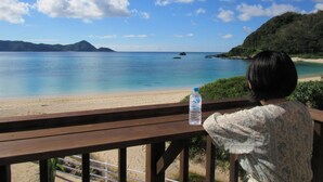 A wooden deck overlooking a beach with clear skies and calm waters. - Amami Lucky House (Amamishi,Kasaricho,OoagiKiseuttabaru)