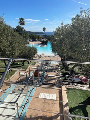 Ein Poolbereich mit freiem Blick auf den Pool, Treppen, die zum Wasser führen, und umgebende Bepflanzung.