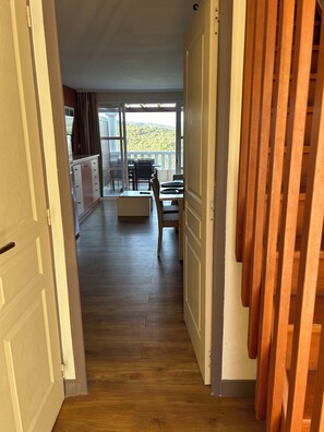 A hallway leading to a balcony with a view of a mountainous landscape. - Duplex in vacation village SEA (Saint-Raphaël)