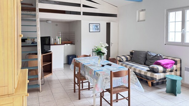 Un espace de vie compact comprenant un coin repas, une kitchenette et un canapé avec vue.