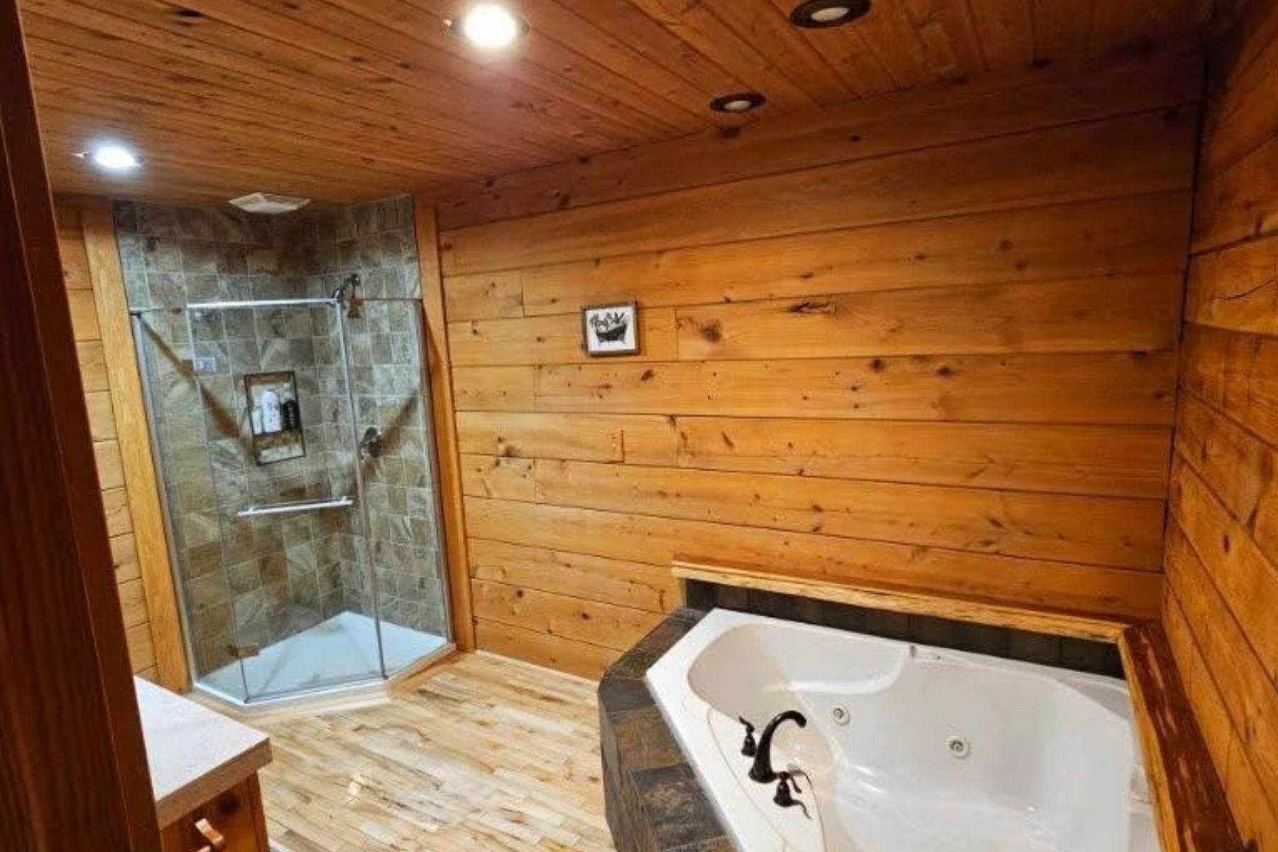 A wooden interior with a glass shower enclosure and a bathtub.