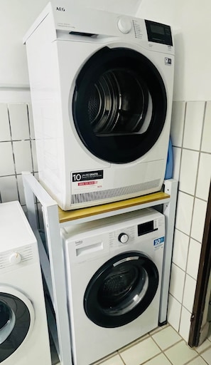 A stacked washer and dryer unit with a control panel and a label indicating a 10-year warranty. - Sanssouci Holiday FeWo 09 (Bad Kissingen)
