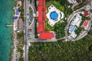 Eine Vogelperspektive eines Resorts mit Pool, Parkplatz und direktem Strandzugang.