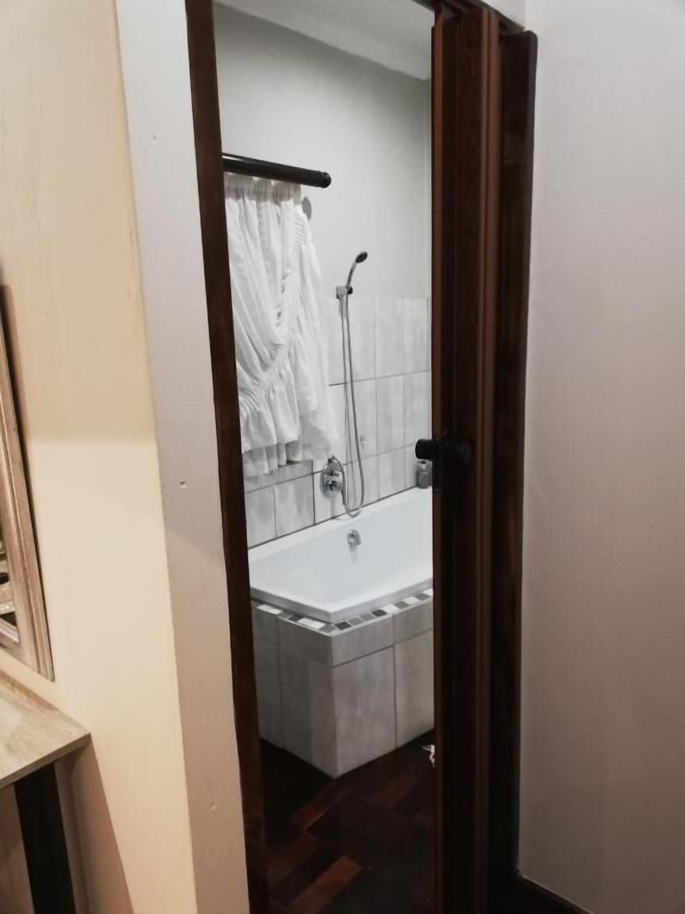 Un baño con bañera, ducha y un perchero para toallas.