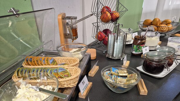A buffet area with various food items, including fruits, condiments, and spreads.