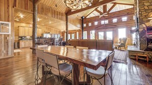 A spacious wooden interior with a large dining table, seating area, and stone accents. - Hot Tub + Fire Pit: Spacious Waynesville Escape! (Waynesville)
