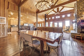 A spacious wooden interior with a large dining table, seating area, and stone accents. - Hot Tub + Fire Pit: Spacious Waynesville Escape! (Waynesville)